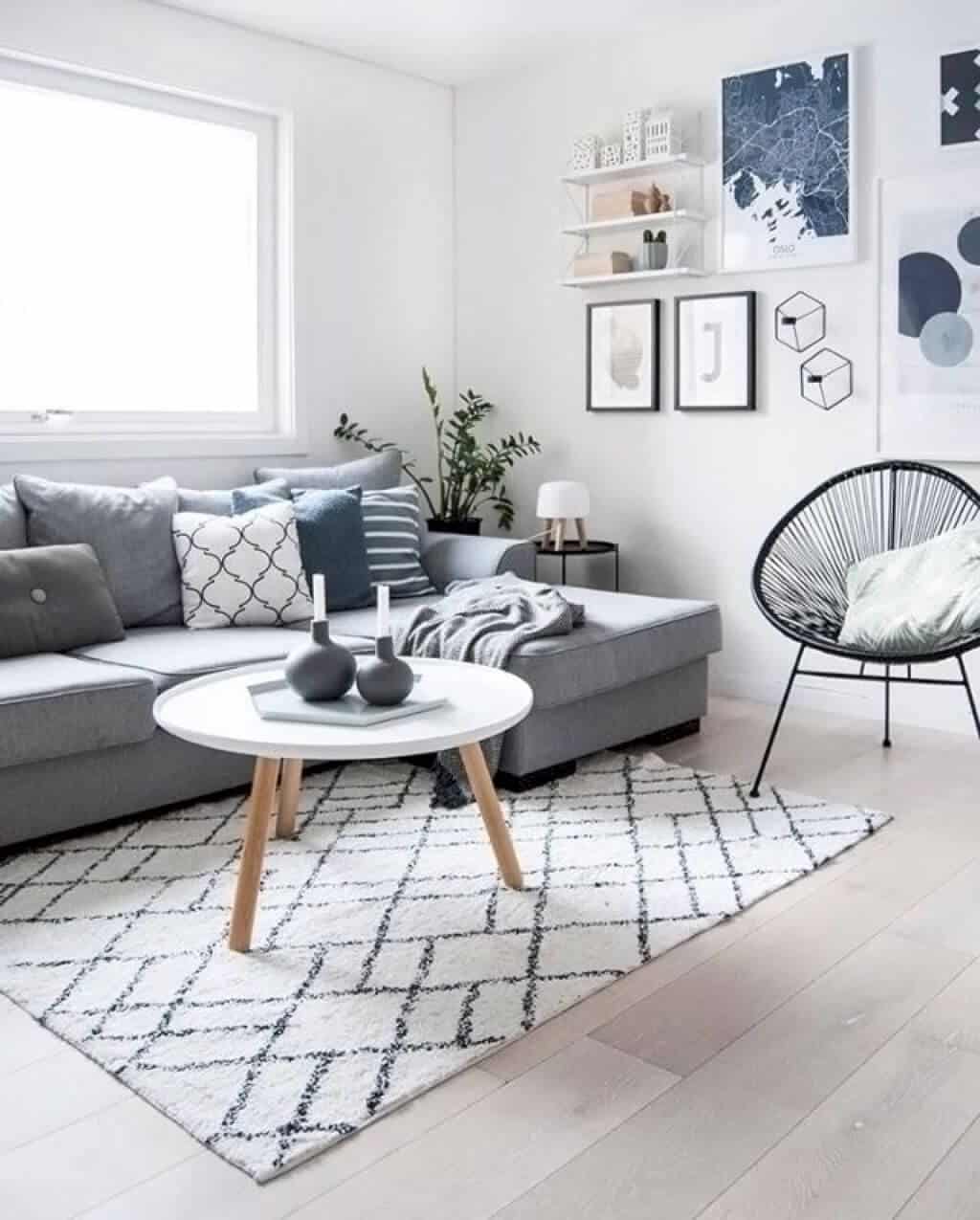 A Scandinavian living room features a light and airy feel with a plush couch, coffee table, and area rug.