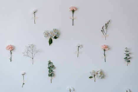 Tape Artificial Flowers And Leaf Sprays To A Bare Wall